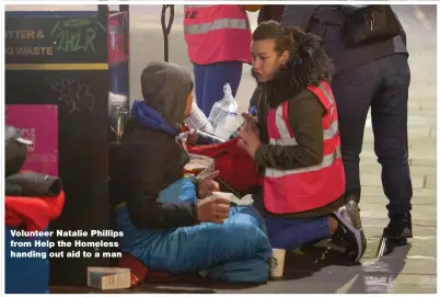  ??  ?? Volunteer Natalie Phillips from Help the Homeless handing out aid to a man