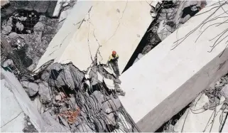  ?? REUTERSPIX ?? Rescue workers search the site of the collapsed Morandi Bridge in Genoa on Tuesday.