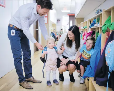  ?? JEFF MCINTOSH/THE CANADIAN PRESS ?? Suncor employees Jenna Pickering, and her husband Shea, pick up their children, Hannah and Luke, from the company’s affiliated daycare in Calgary. The Pickerings, who pay competitiv­e fees for the service, are among the few in Canada to have employers...