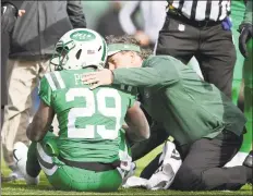  ?? Steven Ryan / Getty Images ?? The Jets’ Bilal Powell is tended to by the trainer during the second quarter against the Minnesota Vikings at MetLife Stadium on Sunday.