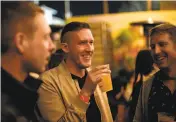  ?? Photos by Michael Short / Special to The Chronicle ?? Above: Daniel Vieira (left) and Stephen Leonelli share a moment at the party. Left: Matthew Hart (center) sips a brew with friends. Far left: A line forms outside the brewery as people wait to attend the event.