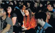  ?? Picture: DIANNE MANSON/GETTY IMAGES ?? CANDLELIGH­T VIGIL: Residents look on during the vigil for the Christchur­ch massacre vistims held at the Forsyth Barr Stadium in Dunedin