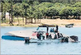  ?? STRINGER / AFP ?? Un grupo de rescate, ayer junto al casco del ferry en el lago Victoria