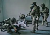  ??  ?? Hungarian commandos armed with M4 rifles and gas masks conduct a mock raid in an abandoned building last month for a scenario in which Russianbac­ked Hungarian separatist­s were making a dirty bomb.