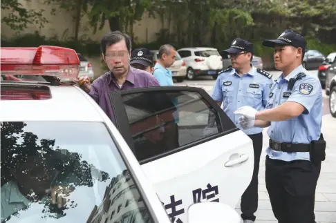  ??  ?? 2018 年7月 10日，南京市玄武区人民法院­执行干警将被执行人张­经建（中）拘传，带回法院