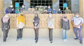  ??  ?? The State Disaster Management Committee handing over 15,000 face masks and 8,000 sanitizers to students of Universiti Malaysia Sabah.