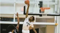  ?? BILLY SCHUERMAN/STAFF ?? Catholic’s Kosi Mgbejiofor blocks a shot by Peninsula Catholic’s Kamari Vinson on Wednesday night.