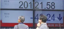  ??  ?? TOKYO: Men look at an electronic stock board showing Japan’s Nikkei 225 index at a securities firm yesterday in Tokyo. Asian stocks were mostly lower yesterday following a drop on Wall Street, as investors looked toward British elections later in the...