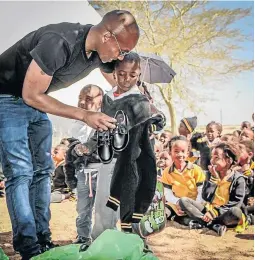  ?? / SUPPLIED ?? Orlando Pirates goalkeeper Jackson Mabokgwane hands over uniforms to pupils at Manchimudi Primary.