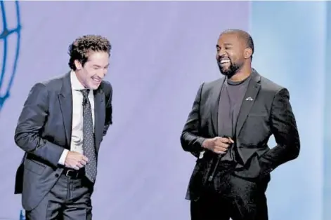  ?? MICHAEL WYKE/AP ?? With their eyes closed for prayer, Joel Osteen and Kanye West laugh as West makes a joke at a service in Osteen’s church.