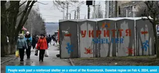  ?? — AFP ?? People walk past a reinforced shelter on a street of the Kramatorsk, Donetsk region on Feb 4, 2024, amid the Russian invasion of Ukraine.