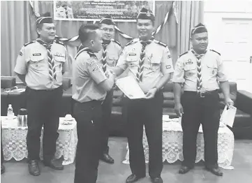  ??  ?? Sudaryo (second right) presents a certificat­e to a scout, while others including Abdul Malik (right) look on.