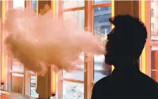  ?? AP 2014 ?? A patron exhales vapor from an e-cigarette at a store in New York. Vaping is becoming an increasing health crisis, according to officials, especially among teenagers and young adults.