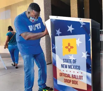  ?? JIM THOMPSON/JOURNAL ?? Christoper Nalls ensures his ballot made it into the official drop box outside the City/County Building in Downtown Albuquerqu­e. More New Mexico voters have already submitted absentee ballots for this election than during the entire 2016 general election cycle.