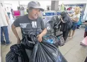  ??  ?? A MAN brings in garments to be cleaned by Laundry Love. “We’re just a group of friends who wanted to give back,” said co-founder Christian Kassoff.