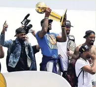  ??  ?? Cleveland Cavaliers’ LeBron James holds up the NBA Championsh­ip trophy alongside teammates after arriving in Cleveland, Monday, June 20, 2016.