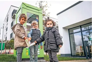  ?? RP-FOTO: HANS-JÜRGEN BAUER ?? Vor dem Fröbel Kindergart­en in Rath steht eine Kinderbüch­erbox. Aicha, Leo und Hira (v.l.) haben sich dort mit neuem Lesestoff eingedeckt.