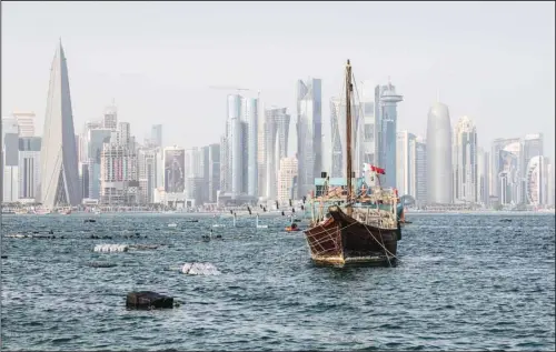  ?? (AP) ?? Old wooden boats anchor at the Doha Corniche in front of the modern skyline on the day before the start of the Soccer World Cup in Doha, Qatar, Nov. 19, 2022.