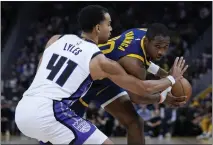  ?? GODOFREDO A. VÁSQUEZ — THE ASSOCIATED PRESS ?? Warriors forward Jonathan Kuminga, right, looks for an open teammate while defended by Sacramento Kings forward Trey Lyles during the second half on Thursday in San Francisco.