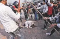  ??  ?? People supporting the new citizenshi­p law beat a Muslim man during a clash with those opposing it in February 2020 in New Delhi