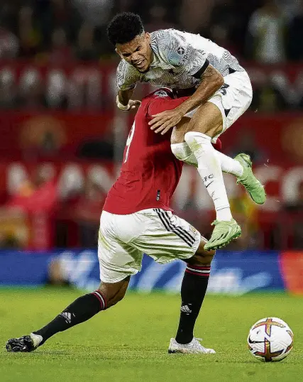  ?? PHOTOS: AP/GETTY IMAGES ?? Uplifting experience . . . Liverpool’s Luis Diaz is fouled by Manchester United’s Raphael Varane during an English Premier League match at Old Trafford stadium in Manchester yesterday. Below: United fans protest about the Glazer ownership of the club outside the stadium before the match.