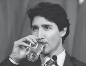  ?? KIRSTY WIGGLESWOR­TH / THE ASSOCIATED PRESS ?? Prime Minister Justin Trudeau takes a drink — no straw, of course — during a press conference at the High Commission of Canada in London on Thursday.