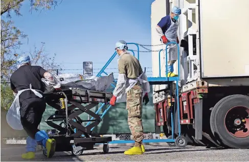  ??  ?? ELEMENTOS de la Guardia nacional de texas ayudan a almacenar cadáveres en la morgue local