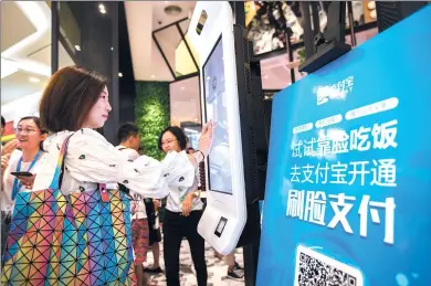  ?? XU KANGPING / FOR CHINA DAILY ?? A customer pays her bill using facial recognitio­n technology at KFC’s concept restaurant KPRO in Hangzhou on Friday.