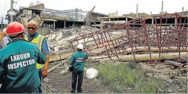  ?? Picture: THULI DLAMINI ?? MANGLED REMAINS: Officials of the Department of Labour carry out an inspection of the collapsed mall