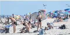  ?? AFP ?? People relax in Miami Beach, Florida which on Thursday reported a record of more than 10,000 new coronaviru­s cases, as it struggles to rein in the virus’s spread.