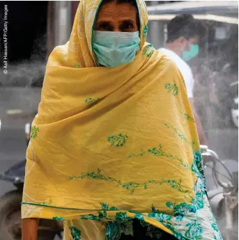  ??  ?? STAYING SAFE: A woman walks through a market area in Karachi on Monday
(8)