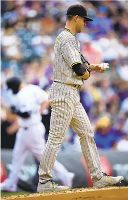  ?? DAVID ZALUBOWSKI AP ?? Padres pitcher MacKenzie Gore (foreground) rubs up a new ball as Colorado’s C.J. Cron (background) circles the bases after a two-run homer in first inning.