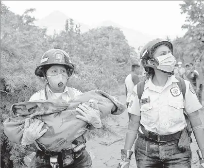  ??  ?? Una rescatista carga a un niño localizado cerca de la volcán de Fuego, en la ciudad de Escuintla, ubicada 35 kilómetros al sur de la capital guatemalte­ca ■ Foto Afp