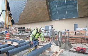  ?? SENTINEL MICHAEL SEARS / MILWAUKEE JOURNAL ?? Workers measure bollards that will be part of the anti-terrorism and lighting system outside the new Milwaukee Bucks arena.