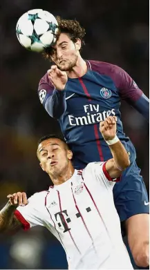  ?? — AP ?? On a high: Paris St Germain’s Adrien Rabiot outjumps Bayern Munich’s Thiago at the Parc des Princes Stadium.