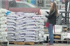  ?? David Zalubowski, The Associated Press ?? A worker takes stock of sacks of potting soil in the garden department outside an Ace Hardware in Denver on March 27.