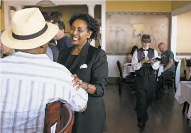  ?? Photos by Brian Feulner / Special to The Chronicle ?? Menbere Aklilu, owner of Salute e Vita, speaks with the Rev. James Harris at her restaurant in Richmond.