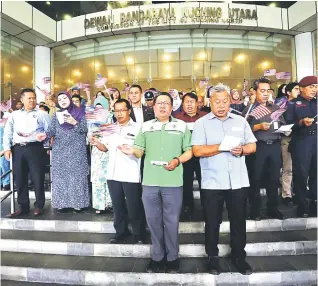  ?? — Gambar Mond Rais Sanusi ?? PATRIOTIK: Pengereja pengawa DBKU sereta (di mua, ari kanan) Morshidi enggau Wee belagu Jalur Gemilang seraya ngepaika menira Malaysia,beserimbai enggau Kimpin ‘Kibar Jalur Gemilang’, kemari.