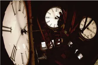 ?? Associated Press file photo ?? Custodian Ray Keen inspects the 100-year-old clock atop the courthouse in Clay Center, Kan., in 2014. For the first time, world timekeeper­s may have to subtract a second in a few years.
