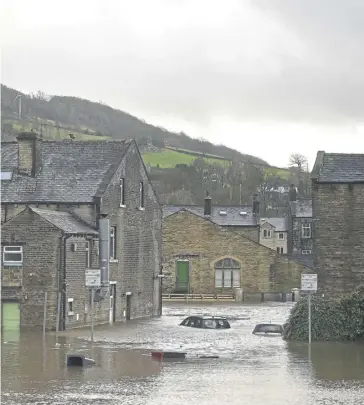  ?? ?? Submerged cars and floating wheelie bins are pictured in a flooded street in Mytholmroy­d, on February 9, 2020, after the River Calder burst its banks as Storm Ciara swept over the country. Photo: Getty Images