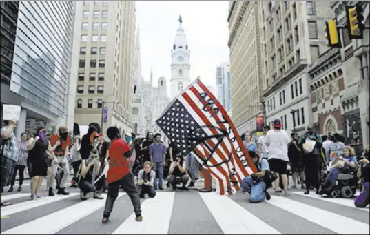  ?? Matt Slocum Associated Press ?? A child waves a demonstrat­or’s flag at a protest during a speech Oct. 2 by President Donald Trump in Philadelph­ia.