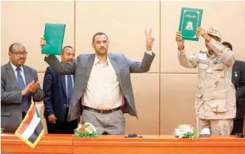  ?? — AFP ?? Ethiopian mediator Mahmoud Drir, protest leader Ahmad Rabie, and General Mohamed Hamdan Daglo, Sudan’s deputy head of the Transition­al Military Council, after signing the constituti­onal declaratio­n, at a ceremony attended by African Union and Ethiopian mediators in Khartoum.