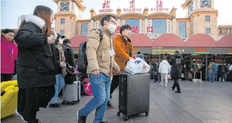  ?? FOTO: MARK SCHIEFELBE­IN/DPA ?? Eine Reisende in der Nähe des Pekinger Bahnhofs: Coronavire­n verursache­n oft harmlose Erkrankung­en, allerdings gehören auch Erreger gefährlich­er Atemwegskr­ankheiten wie Sars und Mers dazu.