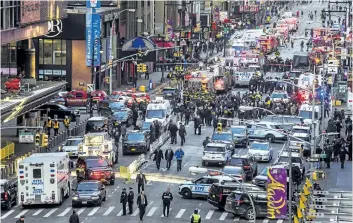  ?? ANDRES KUDACKI/THE ASSOCIATED PRESS ?? Emergency workers are seen following an explosion near New York’s Times Square on Monday. Police say a man with a pipe bomb strapped to his body set off the crude device in a passageway under 42nd St.