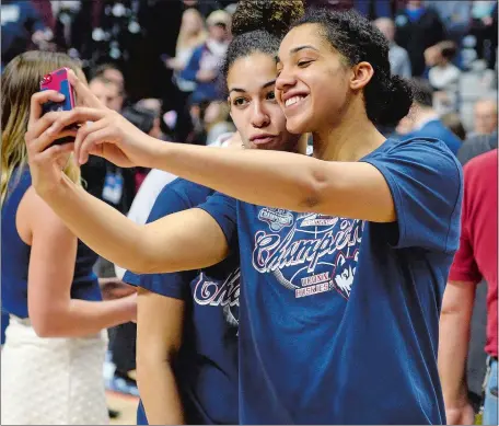  ?? SEAN D. ELLIOT/THE DAY ?? UConn seniors Gabby Williams and Kia Nurse take a selfie together after the trophy presentati­on following their 70-54 win over South Florida in the American Athletic Conference tournament title game at Mohegan Sun Arena on Tuesday. Visit theday.com to...