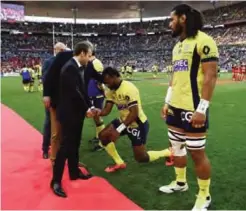  ??  ?? PARIS: French President Emmanuel Macron, left, shakes hand with Clermont’s Peceli Yato as he kneels before him the Top 14 final rugby match between Clermont Ferrand against Toulon at the Stade de France stadium in Saint-Denis, north of Paris, Sunday. —...