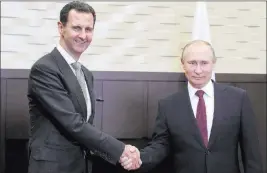  ?? Mikhail Klimentyev ?? The Associated Press Russian President Vladimir Putin shakes the hand of Syrian President Bashar Assad in the Bocharov Ruchei residence Monday in the Black Sea resort of Sochi, Russia. Russian state TV said Tuesday the two leaders held bilateral talks.