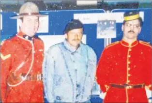  ?? SUBMITTED ?? Wolfgang Jorn poses with RCMP officers at Gander Internatio­nal Airport after asking for asylum in 1988 to escape East Germany.