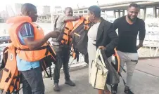  ?? ?? Officials of state-run ferries, Lagos State Waterways Agency (LASWA), collects a life jacket from a passenger on arrival on board a ferry at Falomo jetty in Lagos.