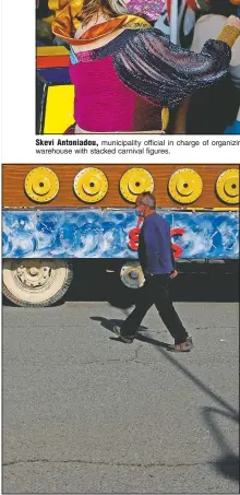  ??  ?? Stelios Kolonas walks next to a carnival float parked outside a warehouse.